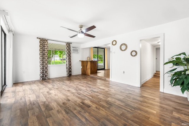 730 E Sherman St, Marion, IN 46952 - unfurnished living room featuring a ceiling fan, wood finished floors, a wall unit AC, and baseboards