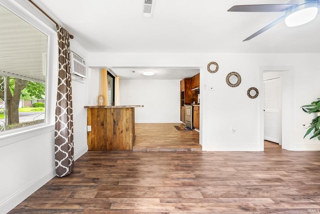 730 E Sherman St, Marion, IN 46952 - unfurnished living room featuring a wall unit AC, wood finished floors, ceiling fan, and baseboards