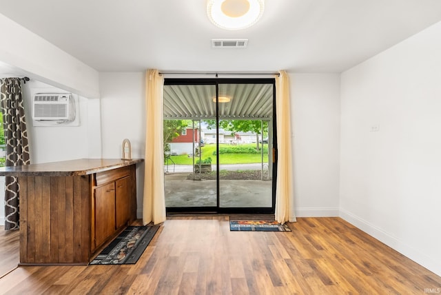 730 E Sherman St, Marion, IN 46952 - unfurnished dining area with a wall mounted AC, wood finished floors, and baseboards