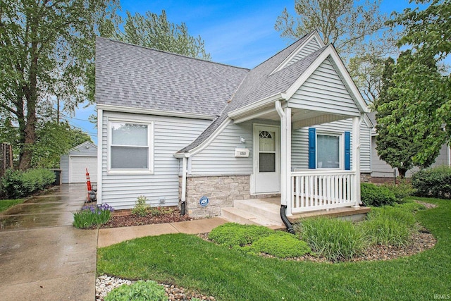 1213 E Bronson St, South Bend, IN 46615 - bungalow-style home featuring a shingled roof, a detached garage, an outbuilding, stone siding, and a front yard