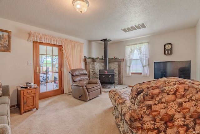 11542 S 700 E, Lafontaine, IN 46940 - living room with a wood stove, a textured ceiling, light carpet, and healthy amount of natural light