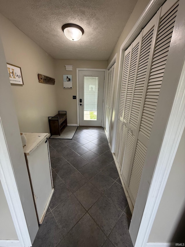 2782 W State Road 32nd Rd, Covington, IN 47932 - doorway to outside with dark tile patterned floors, a textured ceiling, and baseboards