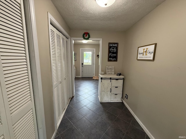 2782 W State Road 32nd Rd, Covington, IN 47932 - hall featuring dark tile patterned flooring, a textured ceiling, and baseboards