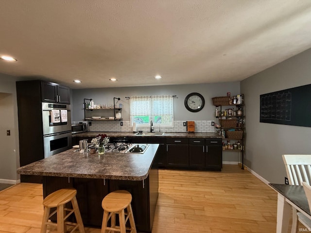 2782 W State Road 32nd Rd, Covington, IN 47932 - kitchen featuring stainless steel appliances, a sink, backsplash, dark countertops, and light wood-type flooring