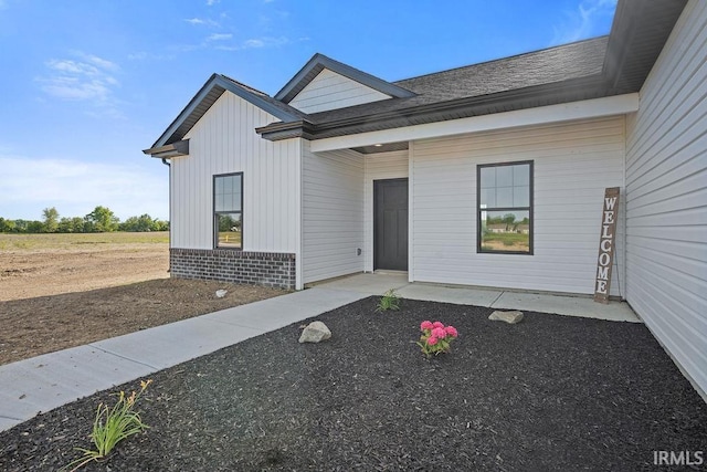 2487 Fiona Dr, Kokomo, IN 46902 - property entrance with board and batten siding, brick siding, and roof with shingles