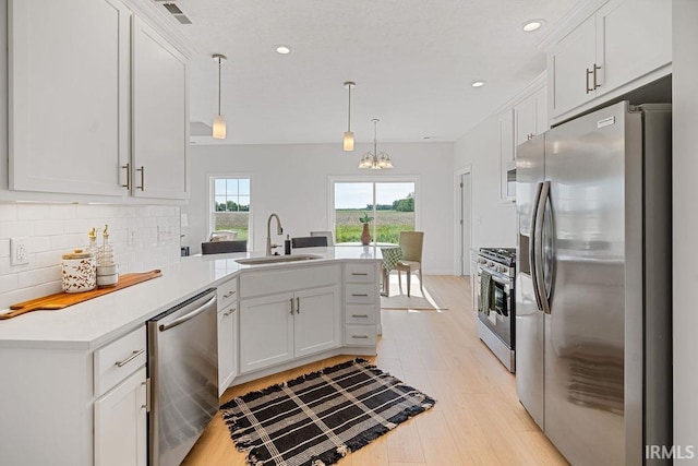 2487 Fiona Dr, Kokomo, IN 46902 - kitchen featuring stainless steel appliances, a sink, a peninsula, decorative backsplash, and a chandelier