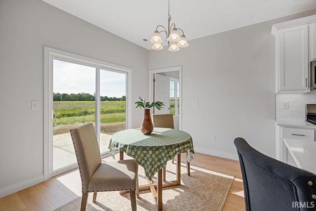 2487 Fiona Dr, Kokomo, IN 46902 - dining space with a chandelier, light wood finished floors, baseboards, and a rural view