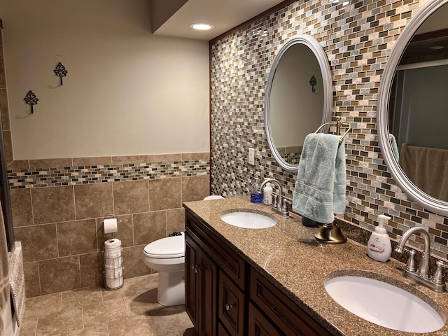 405 N Dogwood Ln, Muncie, IN 47304 - bathroom featuring tile walls, toilet, double vanity, and recessed lighting