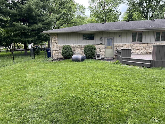 405 N Dogwood Ln, Muncie, IN 47304 - back of house with stone siding, a wooden deck, and roof with shingles