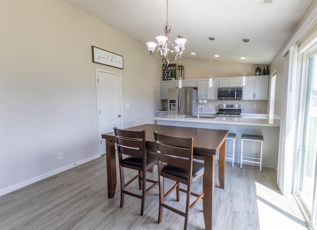 2141 Rutherford Dr, West Lafayette, IN 47906 - kitchen featuring stainless steel appliances, a chandelier, light countertops, light wood-style floors, and lofted ceiling
