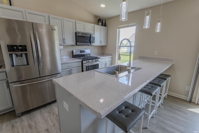 2141 Rutherford Dr, West Lafayette, IN 47906 - kitchen with stainless steel appliances, a sink, light wood-type flooring, a peninsula, and a kitchen breakfast bar