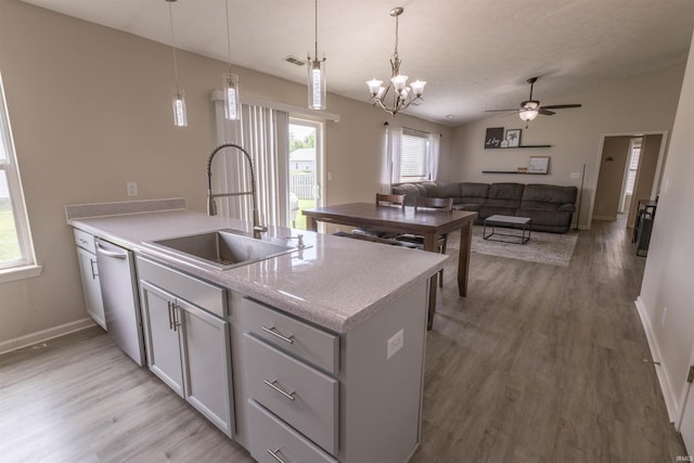 2141 Rutherford Dr, West Lafayette, IN 47906 - kitchen with stainless steel dishwasher, a sink, light wood-type flooring, baseboards, and pendant lighting