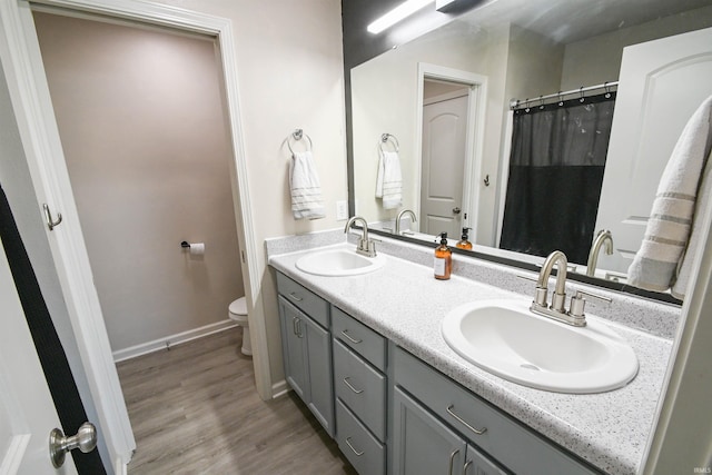 2141 Rutherford Dr, West Lafayette, IN 47906 - full bath featuring toilet, double vanity, wood finished floors, and baseboards