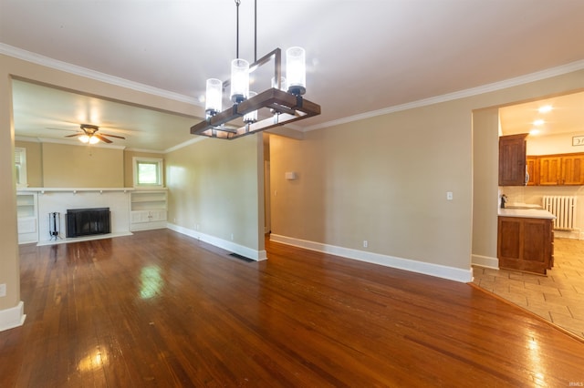 3601 Stringtown Rd, Evansville, IN 47711 - unfurnished living room featuring ornamental molding, hardwood / wood-style floors, baseboards, ceiling fan, and a fireplace with flush hearth