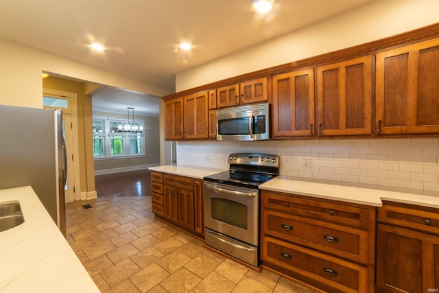 3601 Stringtown Rd, Evansville, IN 47711 - kitchen featuring appliances with stainless steel finishes, tasteful backsplash, brown cabinets, and baseboards