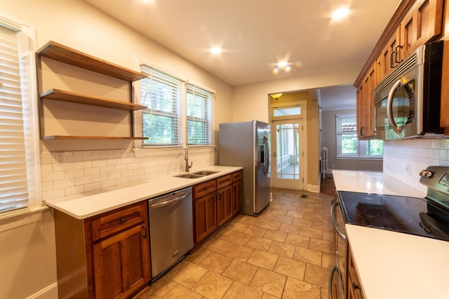 3601 Stringtown Rd, Evansville, IN 47711 - kitchen with appliances with stainless steel finishes, a sink, brown cabinetry, and decorative backsplash
