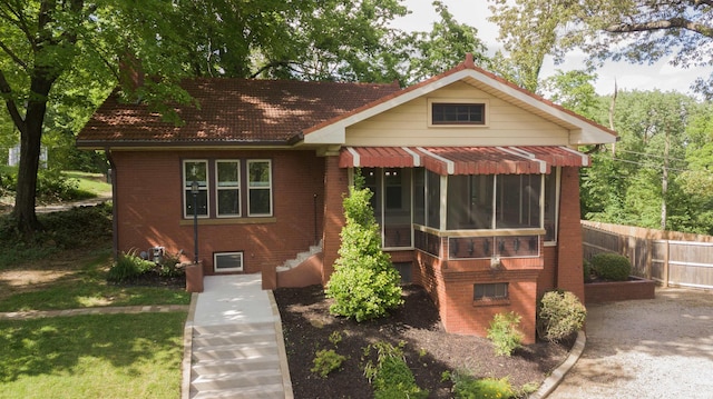 3601 Stringtown Rd, Evansville, IN 47711 - view of front of home featuring a sunroom, brick siding, and a tiled roof
