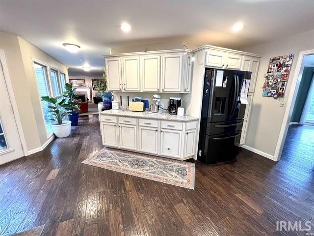 101 Hendron Hills Dr, Vincennes, IN 47591 - kitchen with black refrigerator with ice dispenser, baseboards, dark wood-style flooring, plenty of natural light, and recessed lighting