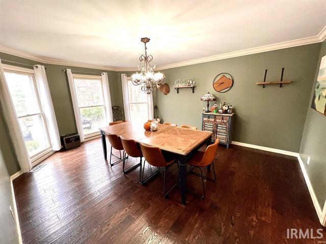 101 Hendron Hills Dr, Vincennes, IN 47591 - dining area featuring ornamental molding, wood finished floors, a chandelier, and baseboards