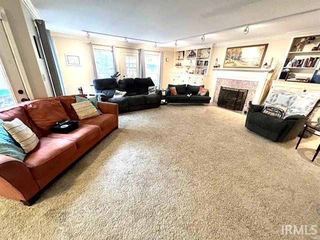 101 Hendron Hills Dr, Vincennes, IN 47591 - carpeted living room with track lighting, crown molding, and a premium fireplace