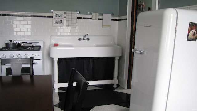 215 S Main St, Oakland City, IN 47660 - kitchen featuring freestanding refrigerator, stainless steel range with gas cooktop, and light countertops