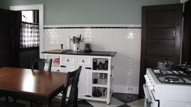 215 S Main St, Oakland City, IN 47660 - kitchen featuring white gas range oven, dark countertops, and white cabinetry