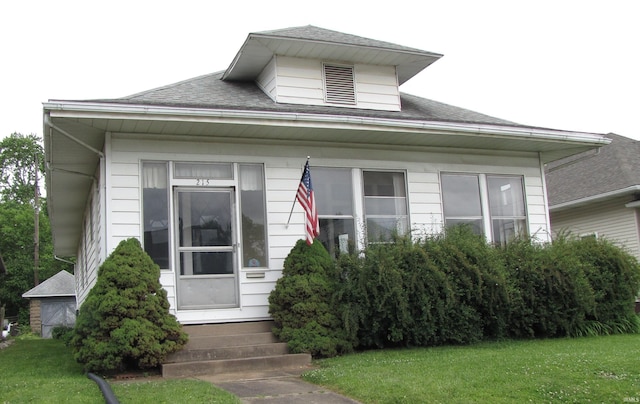 215 S Main St, Oakland City, IN 47660 - bungalow-style home with entry steps, a shingled roof, and a front lawn