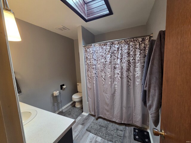 7823 Knightswood Dr, Fort Wayne, IN 46819 - full bath featuring a skylight, vanity, toilet, wood finished floors, and a shower with shower curtain