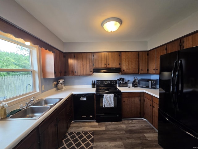 7823 Knightswood Dr, Fort Wayne, IN 46819 - kitchen with black appliances, under cabinet range hood, a sink, light countertops, and dark wood-type flooring