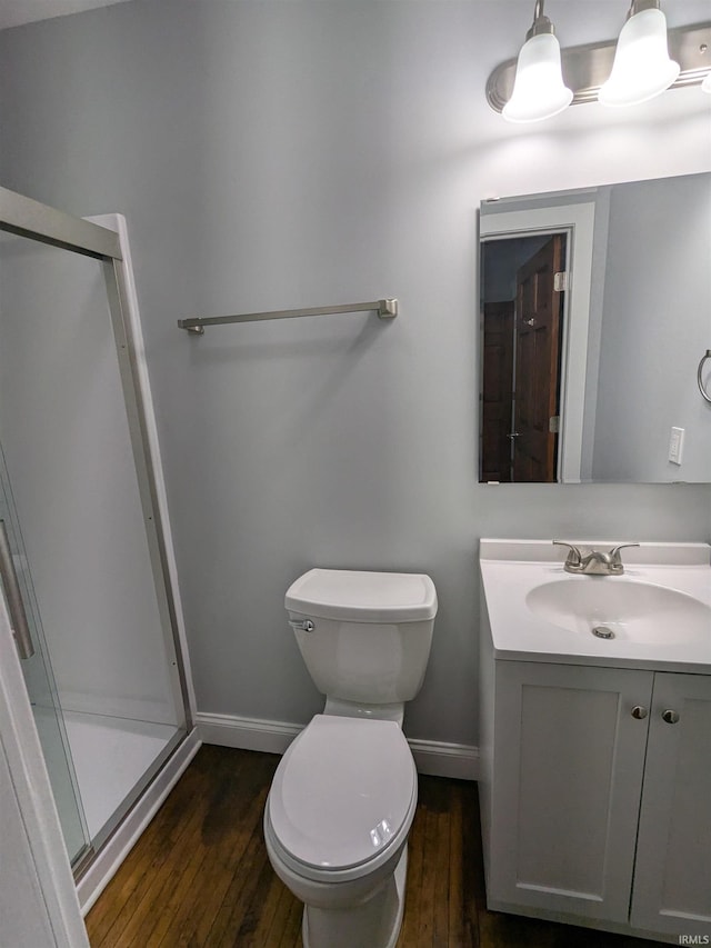 300 E Taylor St, Kokomo, IN 46901 - full bathroom with wood-type flooring, baseboards, vanity, a stall shower, and toilet