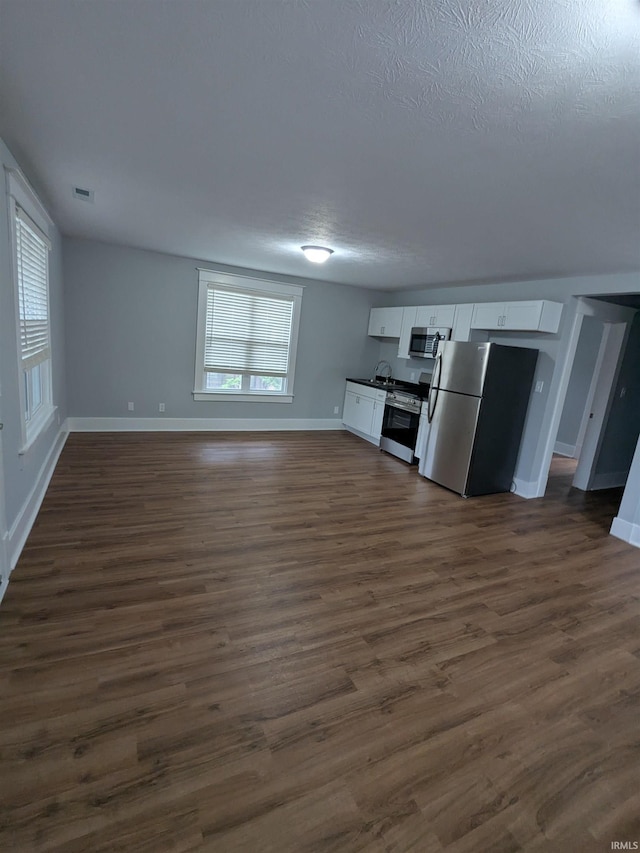 300 E Taylor St, Kokomo, IN 46901 - unfurnished living room with baseboards, dark wood-style floors, a sink, and a textured ceiling