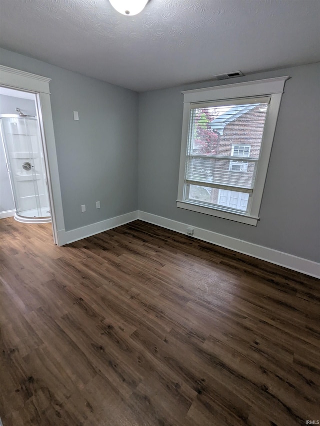 300 E Taylor St, Kokomo, IN 46901 - unfurnished room with dark wood-style floors, baseboards, and a textured ceiling