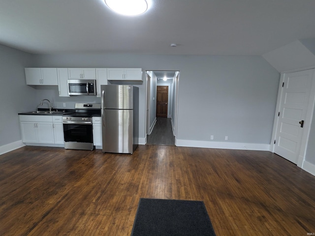 300 E Taylor St, Kokomo, IN 46901 - kitchen with appliances with stainless steel finishes, dark countertops, a sink, baseboards, and white cabinets