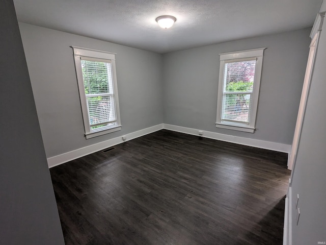 300 E Taylor St, Kokomo, IN 46901 - unfurnished room with baseboards, dark wood finished floors, and a textured ceiling
