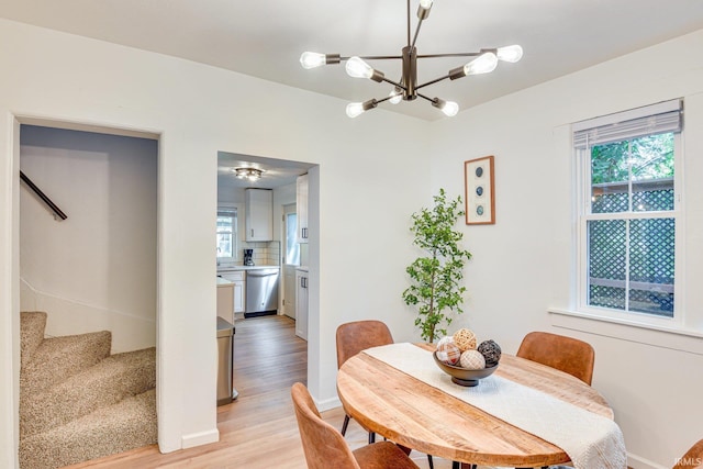 516 W Navarre St, South Bend, IN 46616 - dining space with a chandelier, light wood-type flooring, stairs, and plenty of natural light