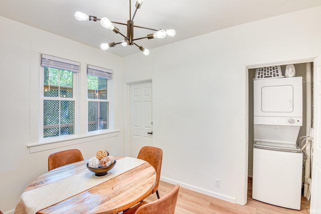 516 W Navarre St, South Bend, IN 46616 - dining room with stacked washer / drying machine, a chandelier, light wood-type flooring, and baseboards