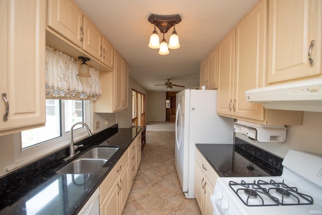 910 S Southland Dr, Lafayette, IN 47909 - kitchen featuring white appliances, a sink, under cabinet range hood, light brown cabinets, and dark stone counters