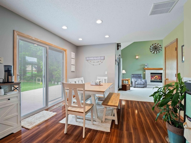 3335 Firethorne Ct, Fort Wayne, IN 46814 - dining space featuring a textured ceiling, a fireplace, dark wood-style flooring, and recessed lighting