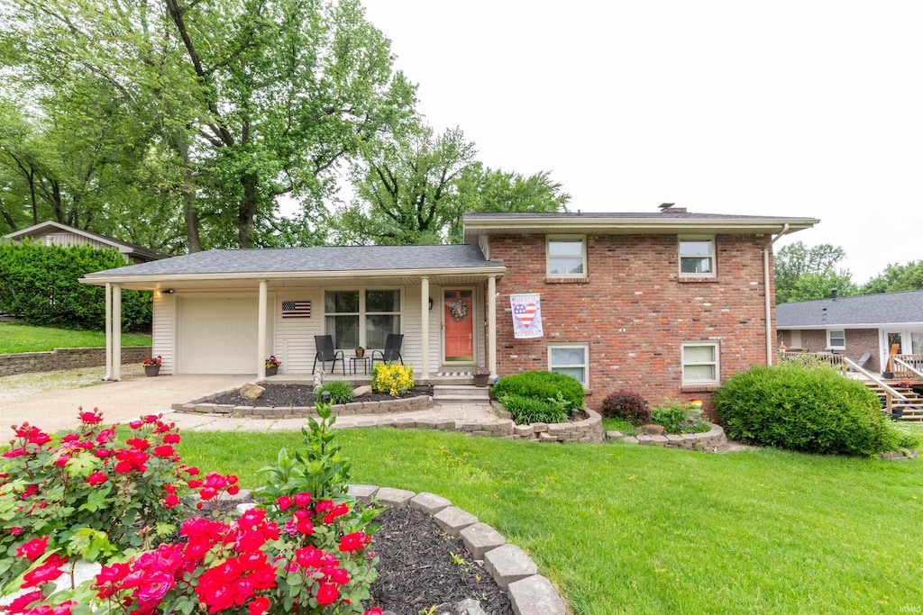 6112 Hamilton Dr, Evansville, IN 47711 - tri-level home featuring covered porch, an attached garage, a front yard, driveway, and brick siding