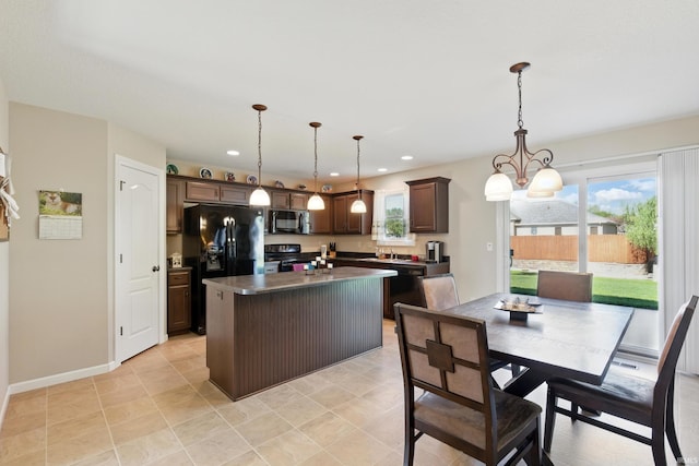 4679 Legacy Cv, Woodburn, IN 46797 - kitchen with black appliances, dark countertops, dark brown cabinetry, a kitchen island, and decorative light fixtures