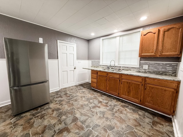 1226 N Union St, Kokomo, IN 46901 - kitchen featuring freestanding refrigerator, a sink, dark stone finish floors, brown cabinets, and wainscoting