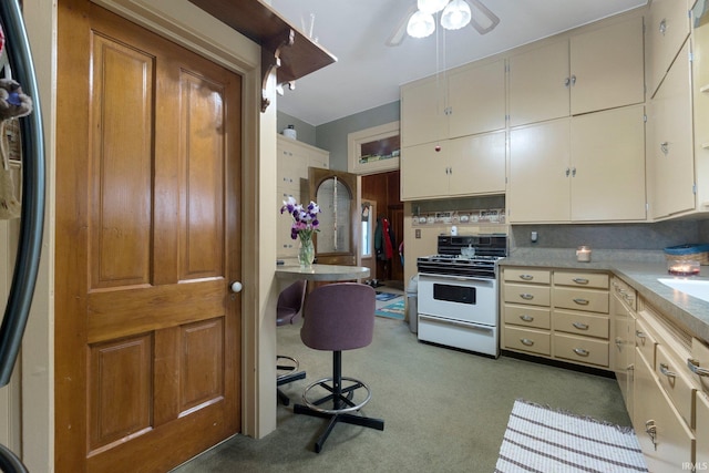 111 N State St, South Whitley, IN 46787 - kitchen featuring gas range gas stove, ceiling fan, light countertops, and light carpet