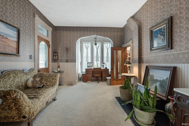 111 N State St, South Whitley, IN 46787 - carpeted living area with wallpapered walls, wainscoting, and arched walkways