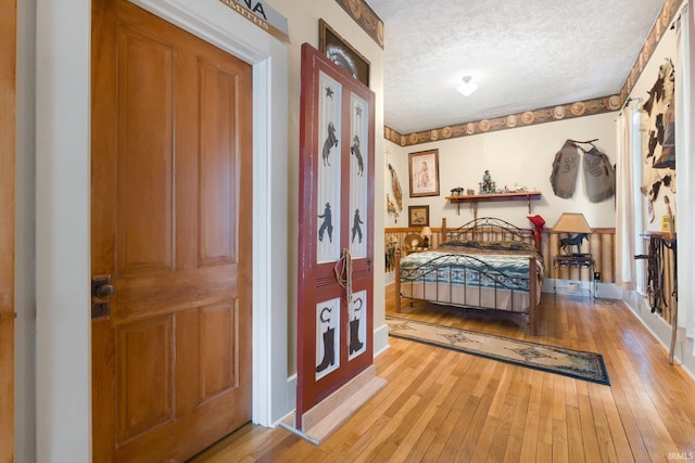 111 N State St, South Whitley, IN 46787 - bedroom with light wood-style floors, a textured ceiling, and baseboards