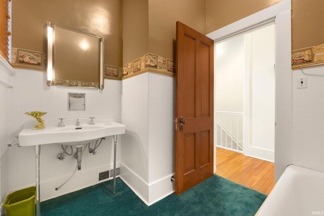 111 N State St, South Whitley, IN 46787 - full bathroom featuring wainscoting, wood finished floors, and a sink