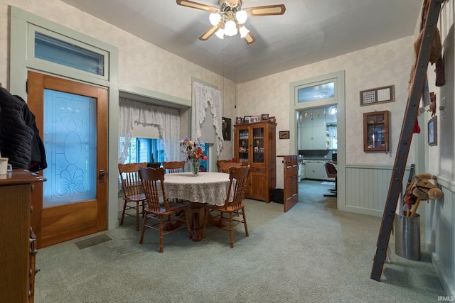 111 N State St, South Whitley, IN 46787 - dining area featuring light carpet, a ceiling fan, and a wainscoted wall
