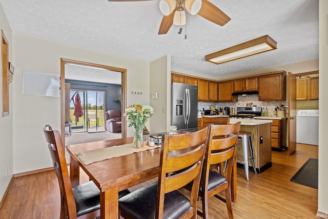 29900 Grant Rd, New Carlisle, IN 46552 - dining area with washer / dryer, light wood-style floors, ceiling fan, and a textured ceiling
