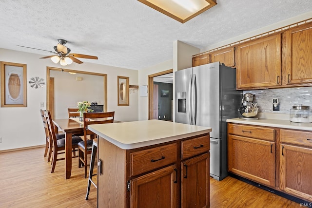 29900 Grant Rd, New Carlisle, IN 46552 - kitchen featuring stainless steel fridge, a textured ceiling, light wood-style floors, light countertops, and a ceiling fan
