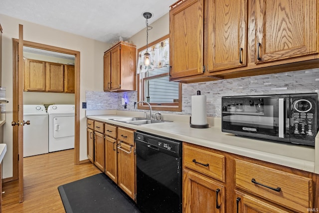 29900 Grant Rd, New Carlisle, IN 46552 - kitchen with black appliances, independent washer and dryer, a sink, backsplash, and light wood-style floors