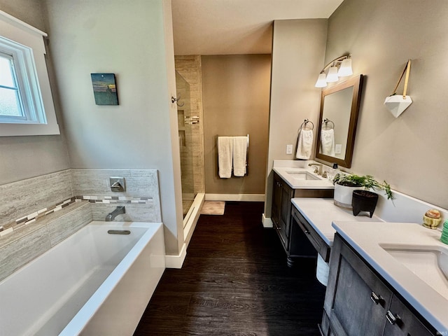 855 N Abigail Ln, Ellettsville, IN 47429 - bathroom featuring double vanity, a bath, a stall shower, wood finished floors, and baseboards